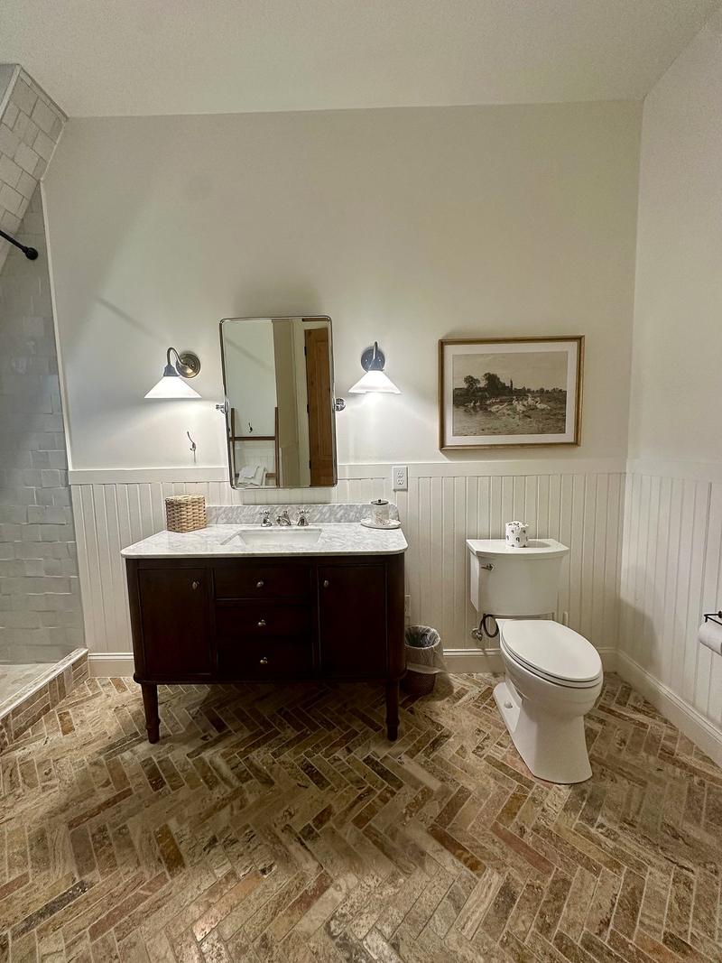 Bathroom remodel with herringbone brick tile, marble vanity and wall sconces by KJ Commercial in NJ