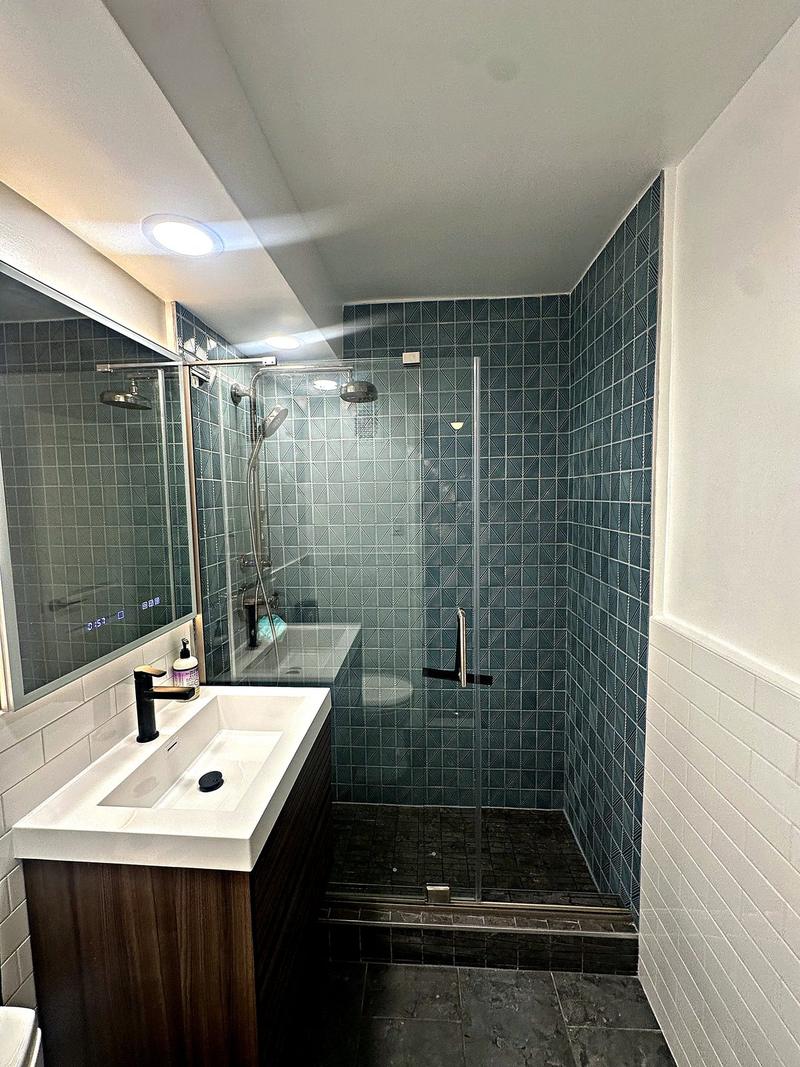 Bathroom remodel with teal tile, glass shower and floating vanity by KJ Commercial in Hudson County NJ