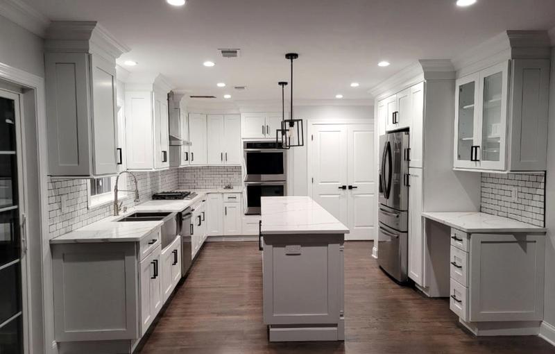 Kitchen remodel with grey shaker cabinets, subway tile backsplash, black hardware, double wall ovens and dark hardwood floors by KJ Commercial in NJ