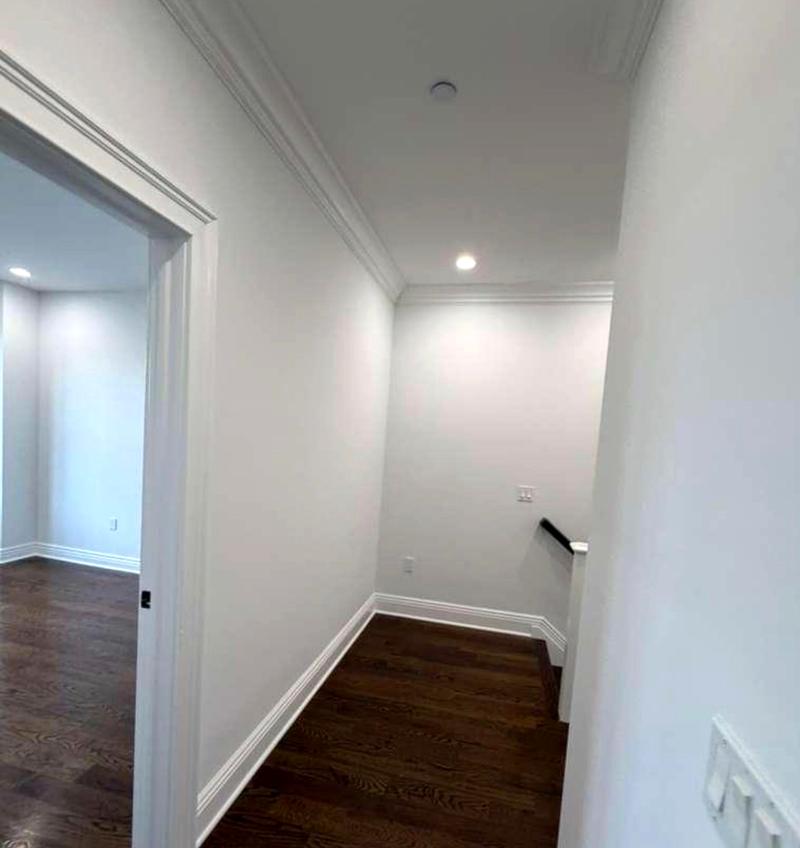 Freshly painted upstairs landing with crown molding, door casing and stair rail by KJ Commercial in Hudson County NJ